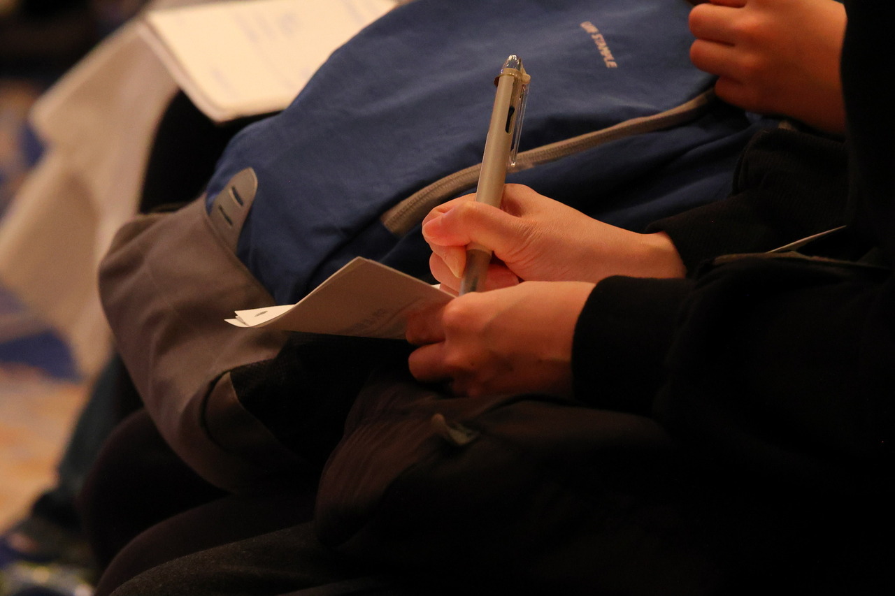 为了孩子明年的升学考试，参加者们正专心致志地做着笔记