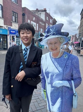 在立教英国学院的户外教学活动中，与伊丽莎白女王的展板合影留念