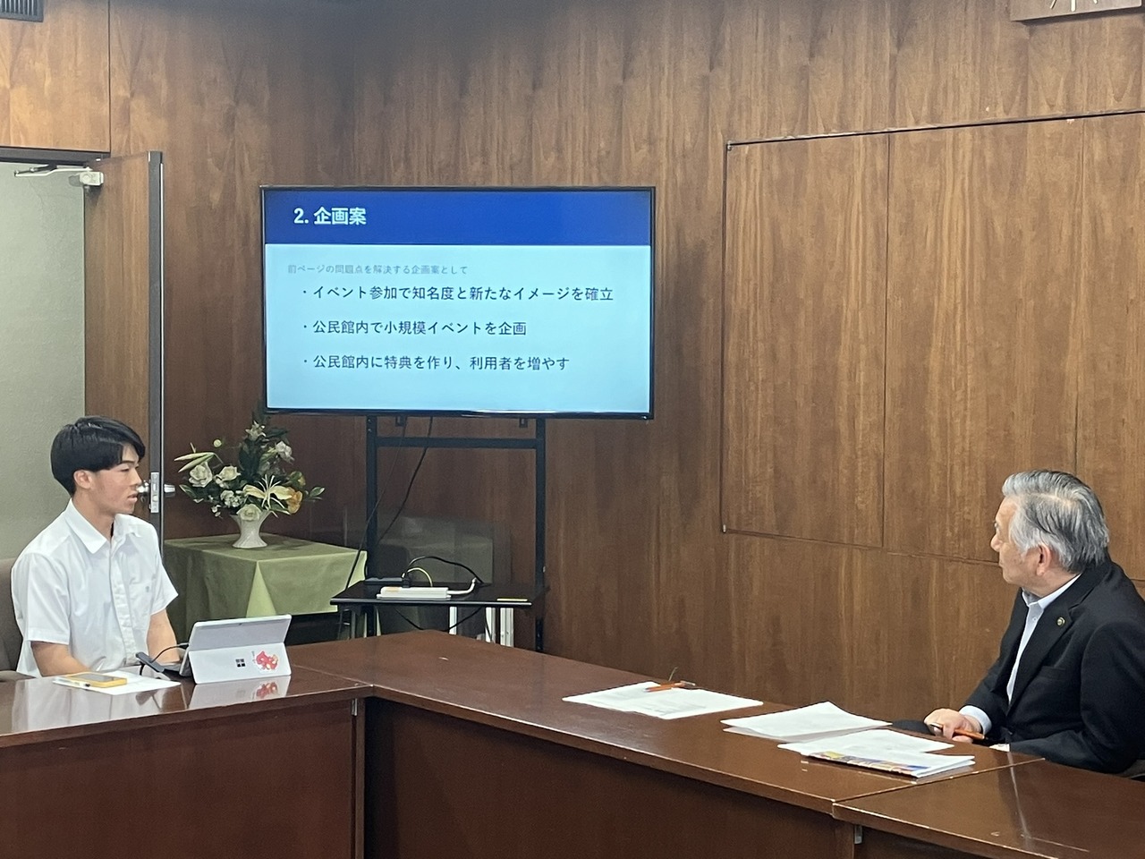 在研讨会例行汇报会上向多摩市市长提出建议的情景