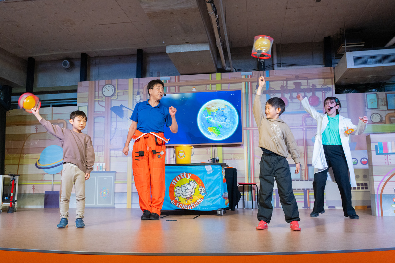 和朋友一起作为科学家见习生登上舞台。把装有球的桶转啊转！